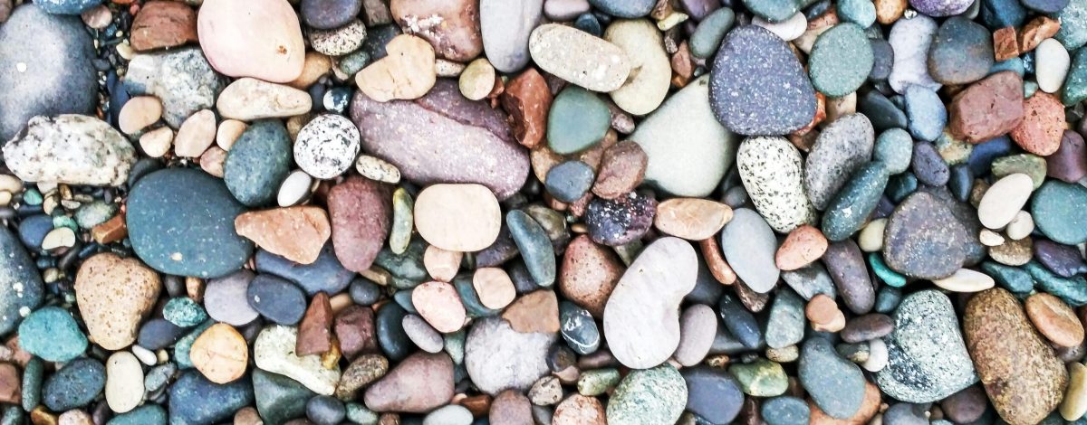 Vibrant collection of smooth, multicolored pebbles and stones arranged closely.